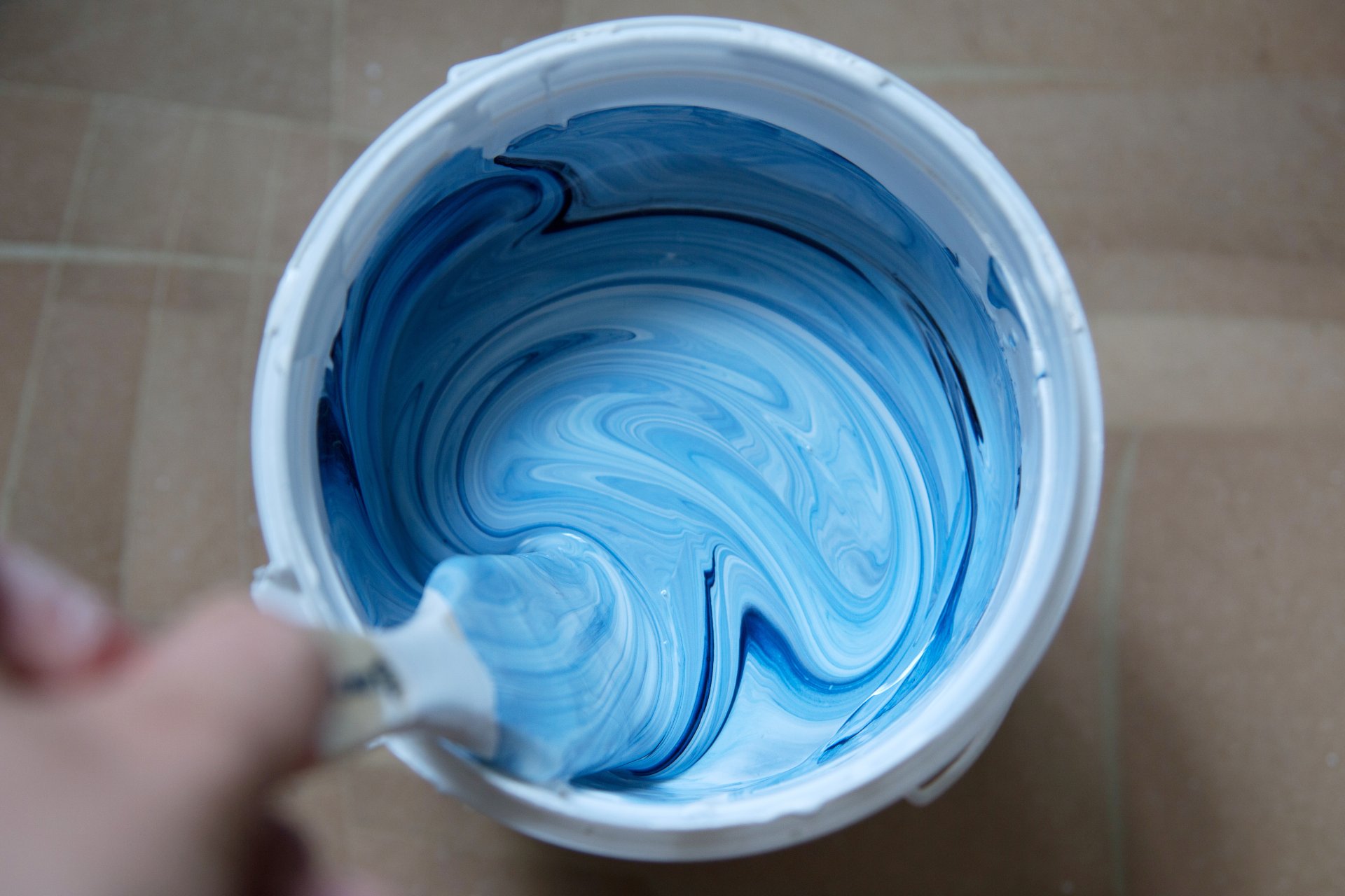 Top view of a can of mixed white and blue paint